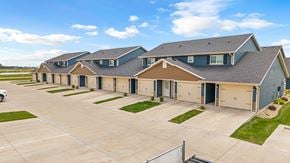 Tea townhouse for rent - A row of houses with garages and driveways.