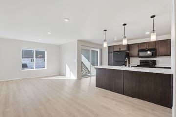 North Sioux City townhouse for rent - A modern kitchen with dark wood cabinets and a white countertop.
