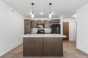 Rapid City apartment for rent - a kitchen with a marble counter top and a black refrigerator
