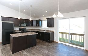 Sioux Falls apartment for rent - an empty kitchen with black cabinets and a large window