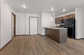 Sioux Falls apartment for rent - A kitchen with a black refrigerator and wooden floors.