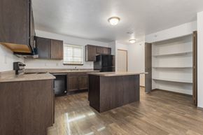 Sioux Falls townhouse for rent - A kitchen with brown cabinets and a wooden floor.