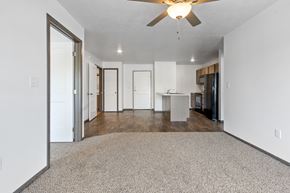 Sioux Falls townhouse for rent - A spacious room with a ceiling fan and a carpeted floor.