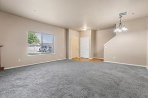 North Sioux City apartment for rent - A spacious room with a grey carpet and a large window.