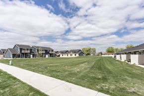 Harrisburg apartment for rent - a grass field in front of a row of houses
