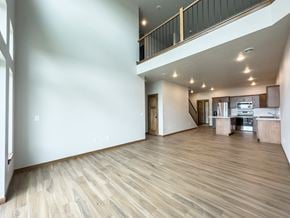 Sioux Falls townhouse for rent - an open living room and kitchen with white walls and wood flooring