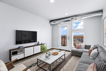 Box Elder apartment for rent - an open living room with a gray couch and a television
