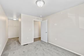 Rapid City apartment for rent - an empty living room with white walls and a door to a closet