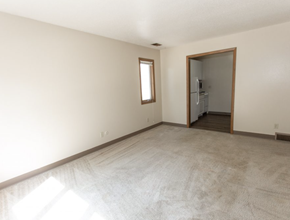 Sioux Falls apartment for rent - an empty living room with white walls and a door to a kitchen