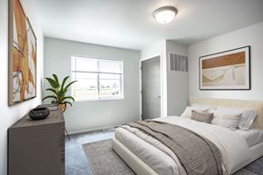 Mitchell apartment for rent - A bedroom with a large bed and a painting on the wall.