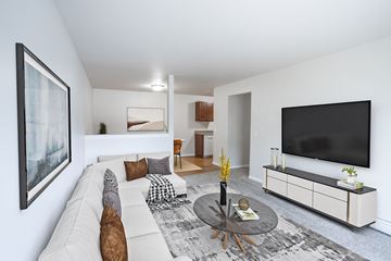 Sioux Falls apartment for rent - A living room with a white couch, a coffee table, and a large painting on the wall.