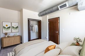 Sioux Falls apartment for rent - A bedroom with a bed, nightstand, and a painting on the wall.