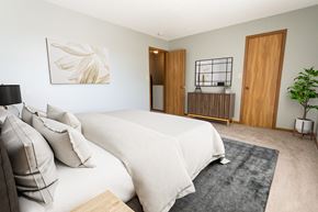 Sioux Falls townhouse for rent - A bedroom with a large bed and a painting on the wall.