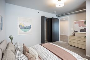 Waukee townhouse for rent - A bedroom with a bed, couch, and artwork on the walls.