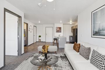 Omaha townhouse for rent - A modern living room with a white sofa and a glass coffee table.