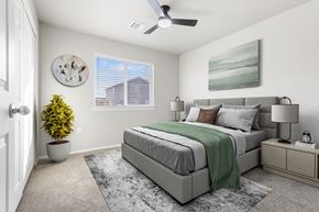 Harrisburg apartment for rent - A bedroom with a bed, nightstand, and a plant.