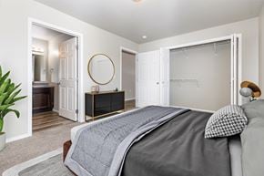 Sioux Falls apartment for rent - A bedroom with a large bed and a dresser with a mirror.