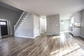 Sioux Falls townhouse for rent - A large empty room with wooden floors and a staircase.