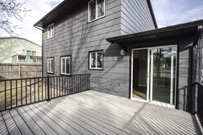 Sioux Falls townhouse for rent - A grey house with a black fence and a glass door.