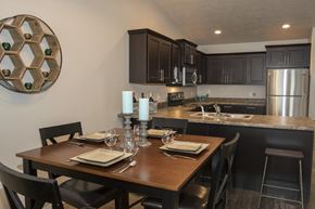 Sioux Falls townhouse for rent - a kitchen and dining area with a wooden table and a stainless steel refrigerator
