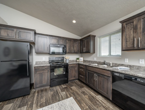Tea townhouse for rent - the kitchen of a home with dark cabinets and stainless steel appliances