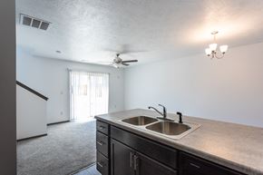 Sioux Falls townhouse for rent - an empty kitchen with a sink and a ceiling fan