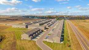 Sioux Falls townhouse for rent - A large, modern building complex sits in a grassy field with a road running in front of it.