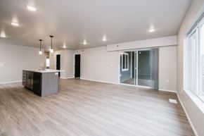 Sioux Falls apartment for rent - A spacious room with a wooden floor and a cabinet in the corner.