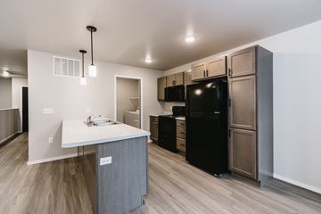 Sioux Falls apartment for rent - A kitchen with a black refrigerator and a white counter top.
