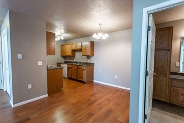 Sioux Falls apartment for rent - a kitchen and living room with wood flooring and wooden cabinets