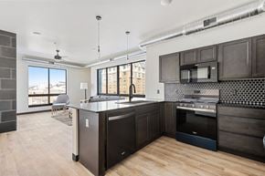 Rapid City apartment for rent - A kitchen with dark wood cabinets and a large island.