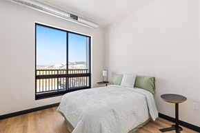 Rapid City apartment for rent - A bedroom with a large bed and a view of the mountains outside.