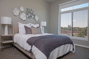 Sioux Falls apartment for rent - a bedroom with a large window and a bed with pillows