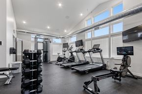 Sioux Falls apartment for rent - A spacious gym with a variety of equipment including treadmills, weights, and a rowing machine.