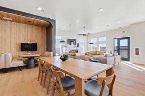 Rapid City apartment for rent - A modern dining room with a long wooden table and chairs.