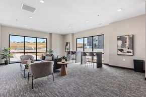 Rapid City townhouse for rent - a lounge area with chairs and a bar in a building with large windows