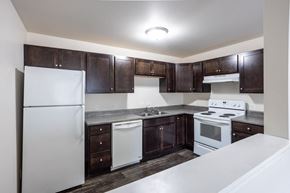 Sioux Falls apartment for rent - a kitchen with white appliances and dark wood cabinets