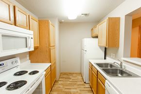 Sioux Falls apartment for rent - a kitchen with white appliances and wooden cabinets