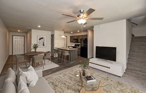 Grimes townhouse for rent - A living room with a couch, a coffee table, a television, and a staircase.