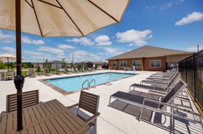 Grimes townhouse for rent - A pool area with sun loungers and a table.