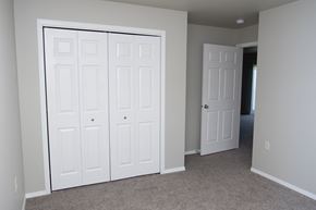 Tea apartment for rent - an empty bedroom with two closets and a door