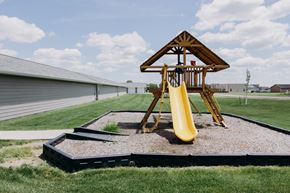 Tea apartment for rent - a playground with a swing set in front of a house