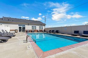 North Sioux City apartment for rent - A swimming pool with a red border and lounge chairs around it.