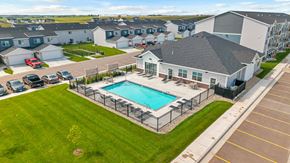 Sioux Falls townhouse for rent - A swimming pool is surrounded by a fence in a grassy area.