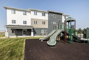 Sioux Falls apartment for rent - a playground with a slide in front of an apartment building