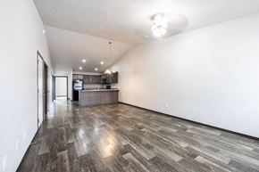 Sioux Falls townhouse for rent - A long, empty hallway with wood flooring and white walls.