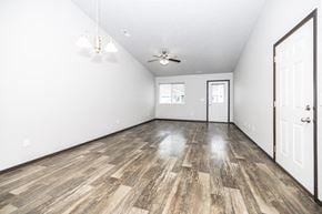 Sioux Falls townhouse for rent - A room with a wooden floor and a ceiling fan.