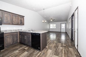 Sioux Falls townhouse for rent - A kitchen with dark wood cabinets and a white counter top.