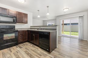 Sioux Falls apartment for rent - A kitchen with dark wood cabinets and black appliances.