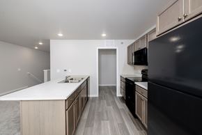 Mitchell apartment for rent - A modern kitchen with a black refrigerator and wooden cabinets.